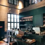 Trendy café interior featuring a modern barista counter with pastries and coffee essentials.